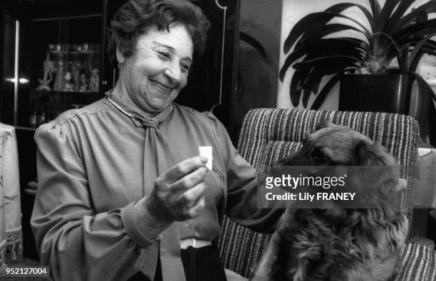 Femme âgée donnant un sucre à son chien dans la maison de retraite ?Jean Rostand? Villeneuve-le-Roi, en mars 1989, dans le Val-de-Marne, France.