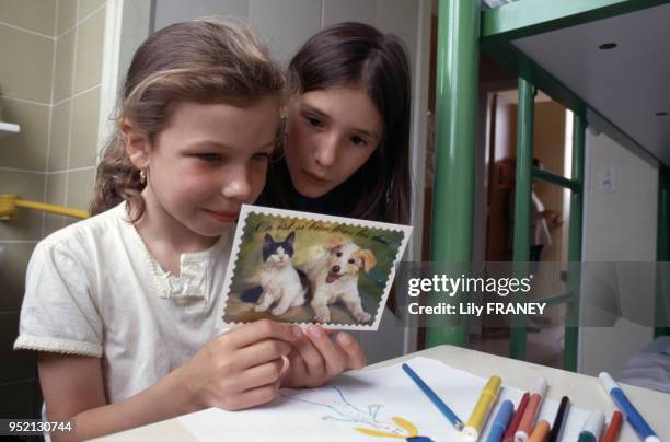 Petite fille lisant une carte postale lors d'une colonie de vacances du Comité Central d'Entreprise de la SNCF à Clairoix, en 2001, dans l'Oise,...