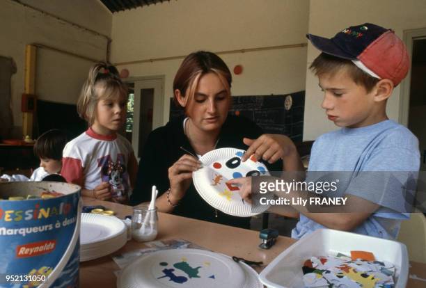 Enfantsfaisant du découpage lors d'une colonie de vacances du Comité Central d'Entreprise de la SNCF à Clairoix, en 2001, dans l'Oise, France.