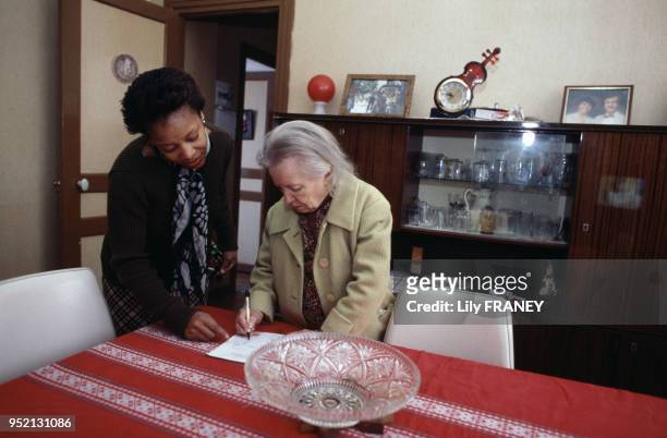 Aide à domicile livrant des repas préparés chez une femme âgée à Vitry-sur-Seine, en janvier 2001, dans le Val-de-Marne, France.