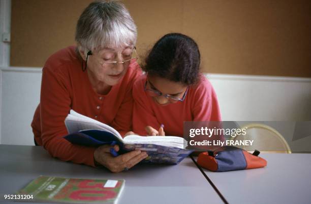 Retraité faisant de l'aide aux devoirs scolaires à Gentilly, en 2000, dans le Val-de-Marne, France.
