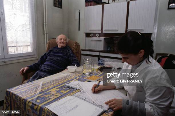 Infirmière à domicile chez un homme âgé à Vitry-sur-Seine, en janvier 2001, dans le Val-de-Marne, France.