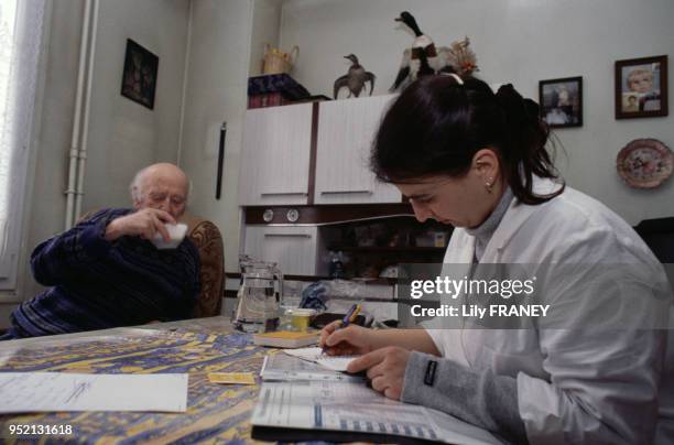 Infirmière à domicile chez un homme âgé à Vitry-sur-Seine, en janvier 2001, dans le Val-de-Marne, France.