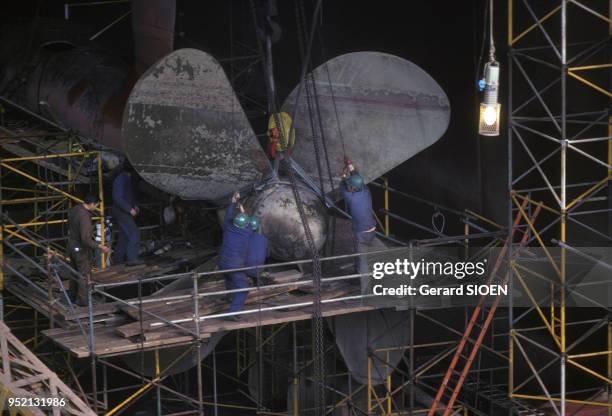 Ouvriers posant l'hélice d'un bateau dans le chantier naval de Saint-Nazaire, en octobre 1987, en Loire-Atlantique, France.