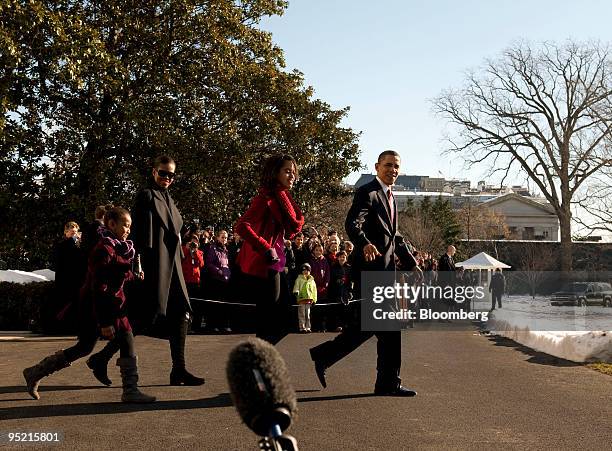 President Barack Obama, right, departs from the White House residence for a trip to Hawaii with his daughter Malia, from right, wife Michelle, and...