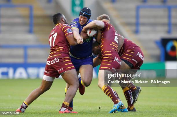 Warrington Wolves' Chris Hill is tackled by Huddersfield Giants Ukuma Ta'ai and Adam O'Brien and Sebastine Ikahihifo during the Betfred Super League...