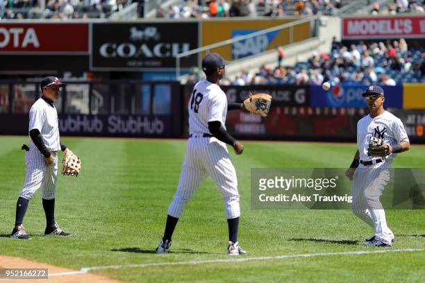 Ronald Torreyes, Didi Gregorius, and Gleyber Torres of the New York Yankees warm up on the field prior to the game against the Minnesota Twins at...