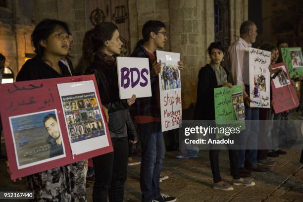 People hold placards during a protest in support of Palestinian journalists, who were martyred by Israeli soldiers during "Great March of Return", in...