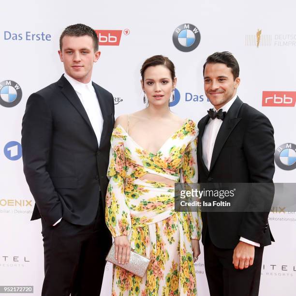 German actors Jannis Niewoehner, Emilia Schuele and Kostja Ullmann attend the Lola - German Film Award red carpet at Messe Berlin on April 27, 2018...