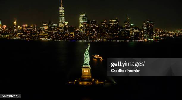 statue of liberty and manhattan at night - new york harbour stock pictures, royalty-free photos & images