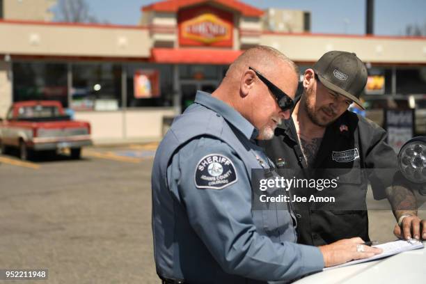 Tim Lambert, Adams County Sheriffs Deputy going over a statement by Peter Pete Stepanek 40, of Thornton and owner of Armageddon Diesel, after he...