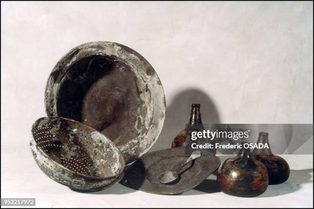 Strainer made of a copper based alloy, a flat serving dish or bucket, glass bottles of wine, a tin plate and spoon all indicate that a certain level...