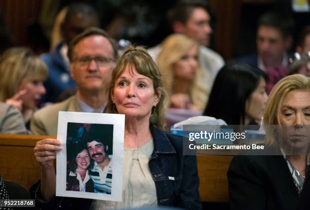 Melanie Barbeau holds a photograph of victims Cheri Domingo and Greg Sanchez during the arraignment of Joseph James DeAngelo, the suspected East Area...