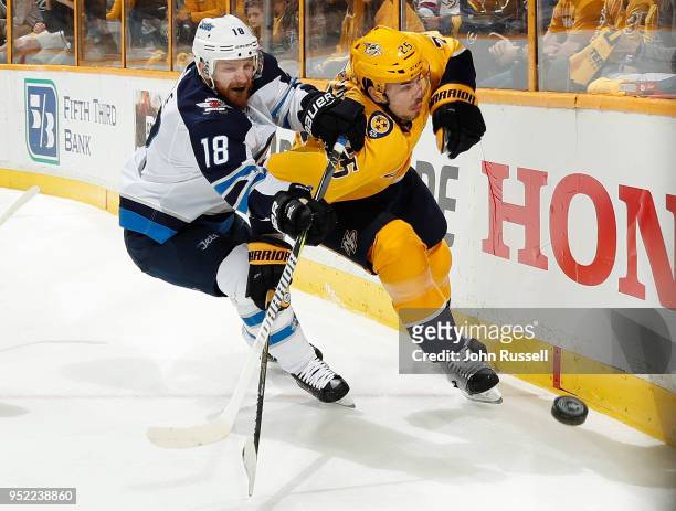 Bryan Little of the Winnipeg Jets battles along the boards against Alexei Emelin of the Nashville Predators in Game One of the Western Conference...