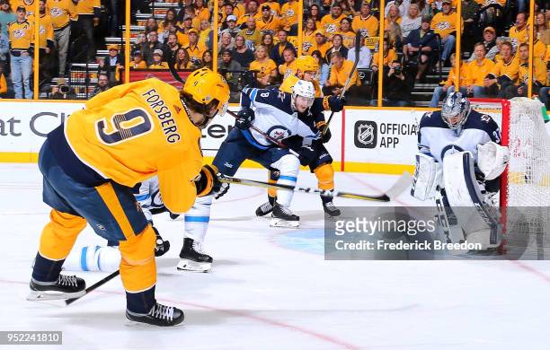 Filip Forsberg of the Nashville Predators takes a shot on goalie Connor Hellebuyck of the Winnipeg Jets during the first period in Game One of the...