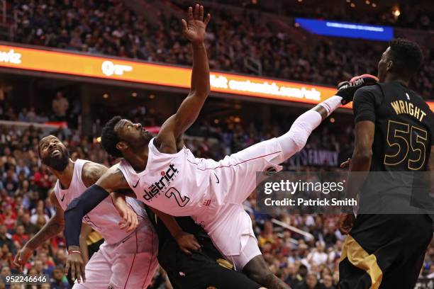 John Wall of the Washington Wizards collides with other players after a shot against the Toronto Raptors in the second half during Game Six of Round...