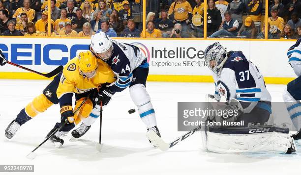 Calle Jarnkrok of the Nashville Predators battles against Josh Morrissey as Connor Hellebuyck of the Winnipeg Jets makes the save in Game One of the...