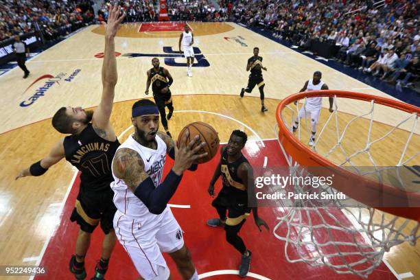 Mike Scott of the Washington Wizards shoots in front of Jonas Valanciunas of the Toronto Raptors in the first half during Game Six of Round One of...