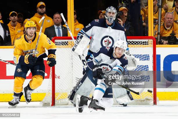 Andrew Copp of the Winnipeg Jets shoots for an empty net against Kevin Fiala of the Nashville Predators in Game One of the Western Conference Second...