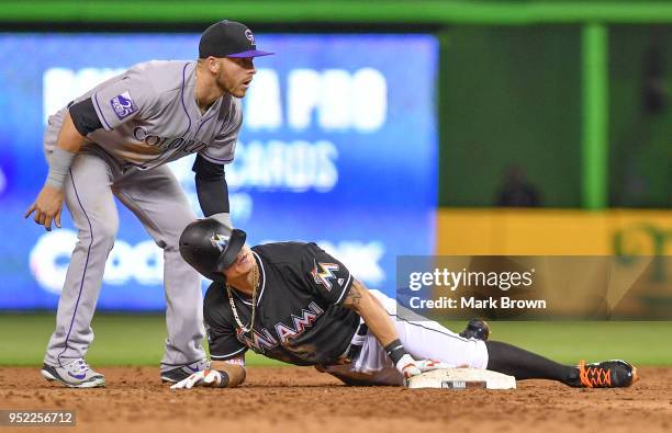 Derek Dietrich of the Miami Marlins with a pinch hit double slides into second in the ninth inning against the Colorado Rockies at Marlins Park on...