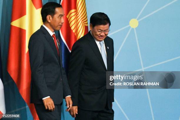 Indonesian President Joko Widodo and Lao Prime Minister Thongloun Sisoulith walk off the stage after a group photograph at the 32nd ASEAN Summit in...