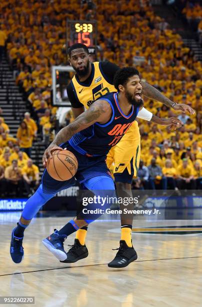 Paul George of the Oklahoma City Thunder drives around the defense of Royce O'Neale of the Utah Jazz in the first half during Game Six of Round One...