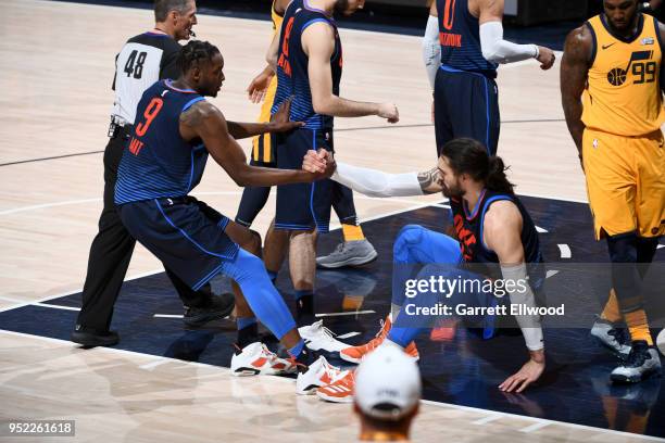 Jerami Grant helps up Steven Adams of the Oklahoma City Thunder in Game Six of the Western Conference Quarterfinals against the Utah Jazz during the...