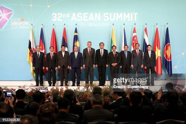 Attendees of the Association of Southeast Asian Nations Summit stand for a photograph during the summit's opening ceremony in Singapore, on Saturday,...