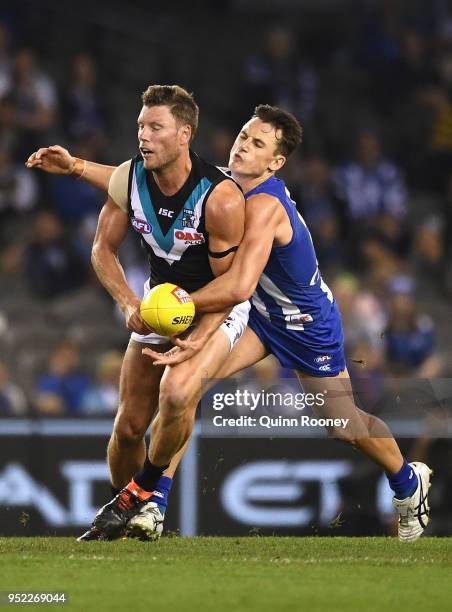 Brad Ebert of the Power handballs whilst being tackled by Ben Jacobs of the Kangaroos during the round six AFL match between the North Melbourne...