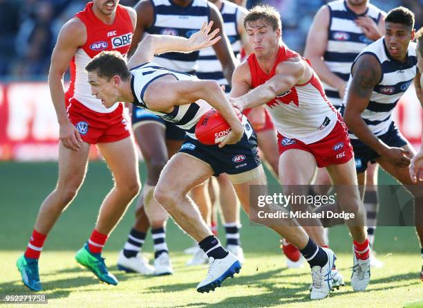 Joel Selwood of the Cats runs with the ball from Kieren Jack of the Swans during the round six AFL match between the Geelong Cats and Sydney Swans at...