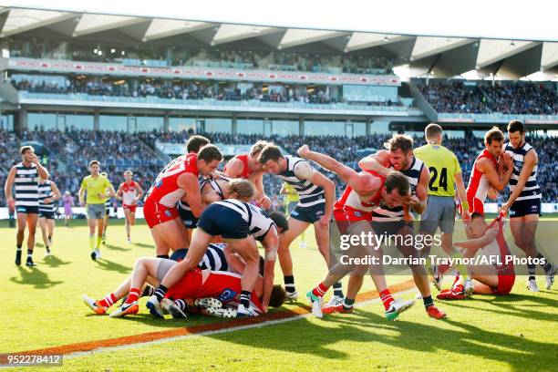 Geelong Cats and Sydney Swans players wrestle during the round six AFL match between the Geelong Cats and Sydney Swans at GMHBA Stadium on April 28,...