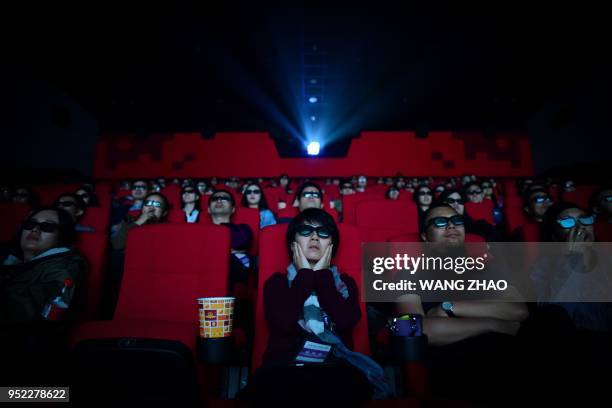 This picture taken on April 27, 2018 shows people watching a movie at a cinema in Wanda Group's Oriental Movie Metropolis in Qingdao, China's...