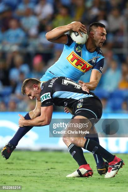 Ryan James of the Titans is tackled during the round eight NRL match between the Gold Coast Titans and Cronulla Sharks at Cbus Super Stadium on April...