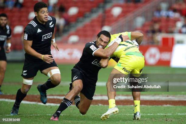 Sione Molia of New Zealand tackles Maurice Longbottom of Australia during the 2018 Singapore Sevens Pool D match between New Zealand and Australia at...