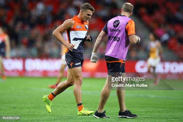 Zac Langdon of the Giants leaves the field with the trainer during the round six AFL match between the Greater Western Sydney Giants and the Brisbane...
