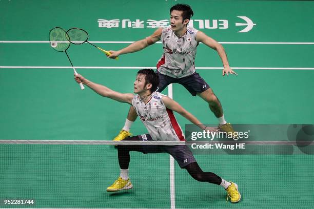 Takeshi Kamura and Keigo Sonoda of Japan hits a return during their man's doubles Semi final match against Liu Cheng and Zhang Nan of China at the...