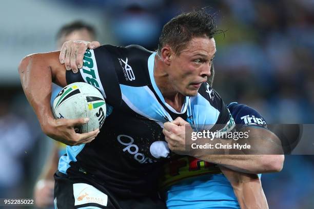 Scott Sorensen of the Sharks is tackled during the round eight NRL match between the Gold Coast Titans and Cronulla Sharks at Cbus Super Stadium on...