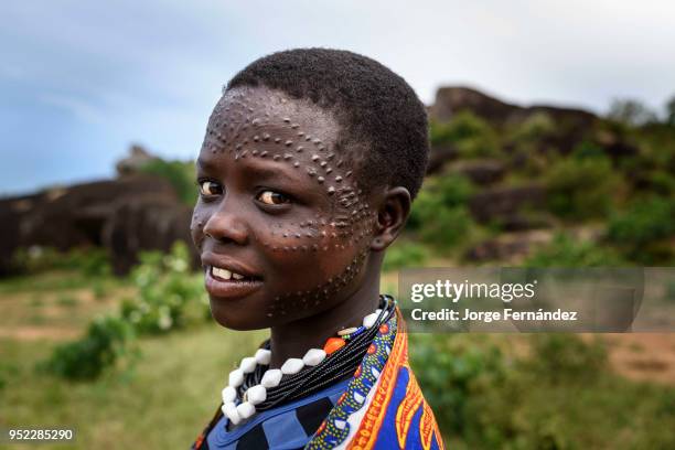 Portrait of a young Karamajong woman with traditional scars on her face.