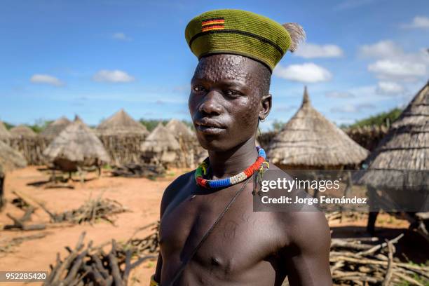 Portrait of a karamajong man with scars on his face forming a pattern as a beauty and identity sign. I took his portrait inside one of the fortified...