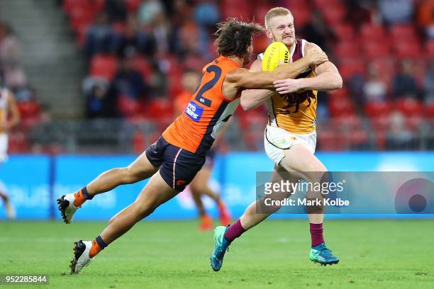 Jake Barrett of the Giants is tackled Nick Robertson of the Lions during the round six AFL match between the Greater Western Sydney Giants and the...