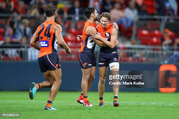 Lachie Whitfield of the Giants celebrates with his team mates after kicking a goal during the round six AFL match between the Greater Western Sydney...