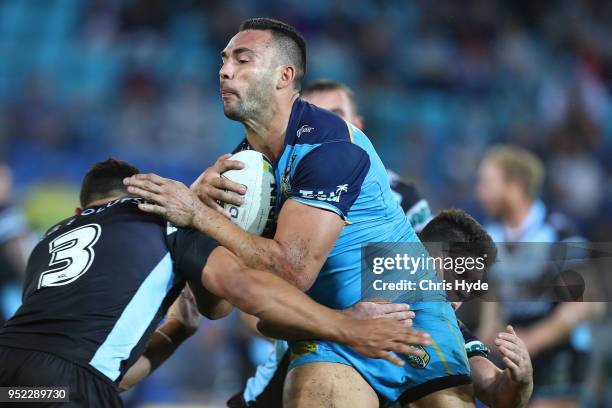 Ryan James of the Titans is tackled during the round eight NRL match between the Gold Coast Titans and Cronulla Sharks at Cbus Super Stadium on April...