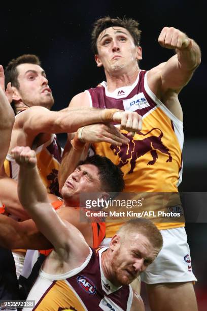 Oscar McInerney and Nick Robertson of the Lions compete against Jonathon Patton of the Giants during the round six AFL match between the Greater...