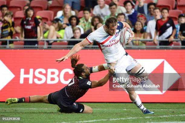 Ben Pinkelman of USA fends off a challenge from Dan Bibby of England during the 2018 Singapore Sevens Pool B match between USA and England at...