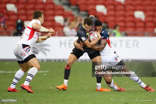 Martin Iosefo of USA tackles Oliver Lindsay-Hague of England during the 2018 Singapore Sevens Pool B match between USA and England at National...