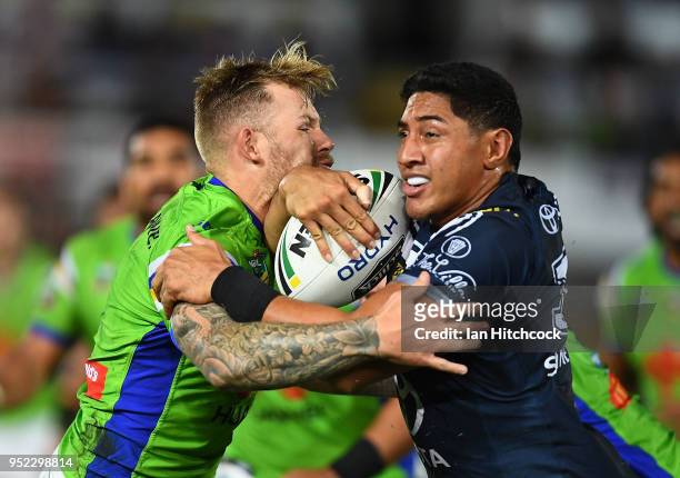 Jason Taumalolo of the Cowboys is tackled by Blake Austin of the Raiders during the round eight NRL match between the North Queensland Cowboys and...