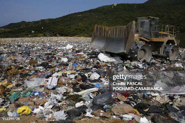 Landfill compactor works at the Viggianello landfill in Propriano on April 27, 2018 on the French Mediterranean island of Corsica. - Collectives of...