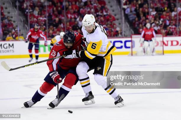 Devante Smith-Pelly of the Washington Capitals and Jamie Oleksiak of the Pittsburgh Penguins battle for the puck in the first period in Game One of...