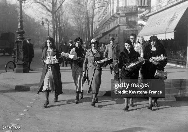 Union Féminine Française vend des bonbons au profit des familles des victimes des journées d'émeute à Paris, France en février 1934.