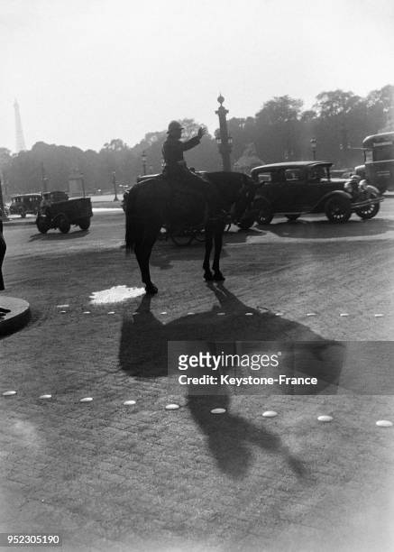 Un agent mont�é projette une ombre gigantesque place de la Concorde, à Paris, France en septembre 1933.